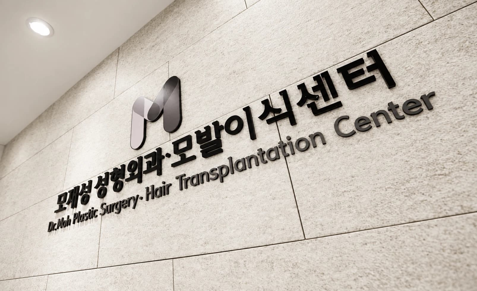 석재 벽에 부착된 모재성 성형외과·모발이식센터 사인